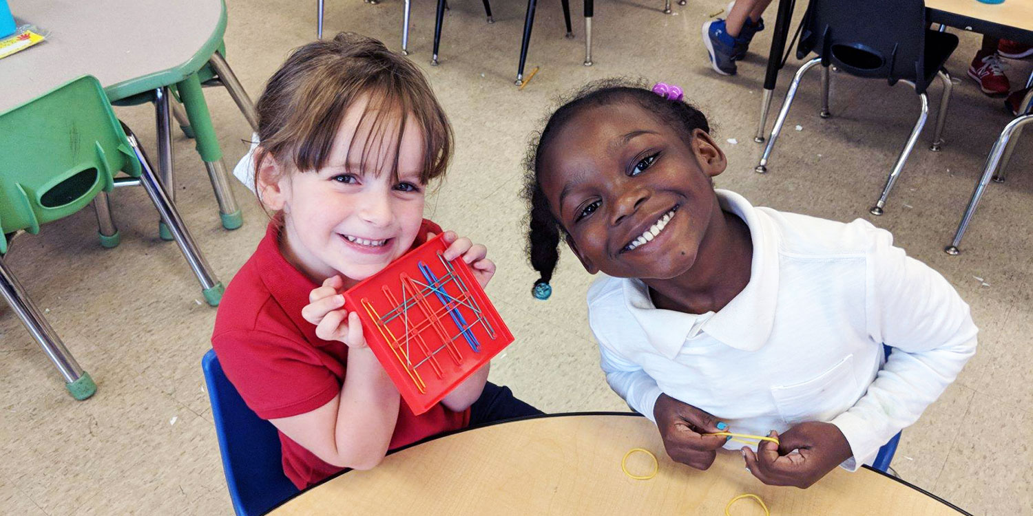 Smiling elementary students showing an activity in a classroom.
