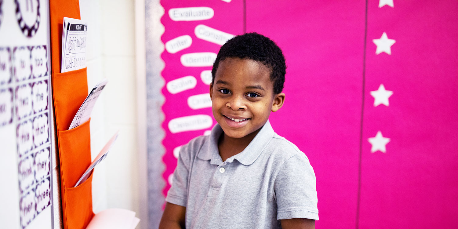 Smiling elementary student in a classroom.